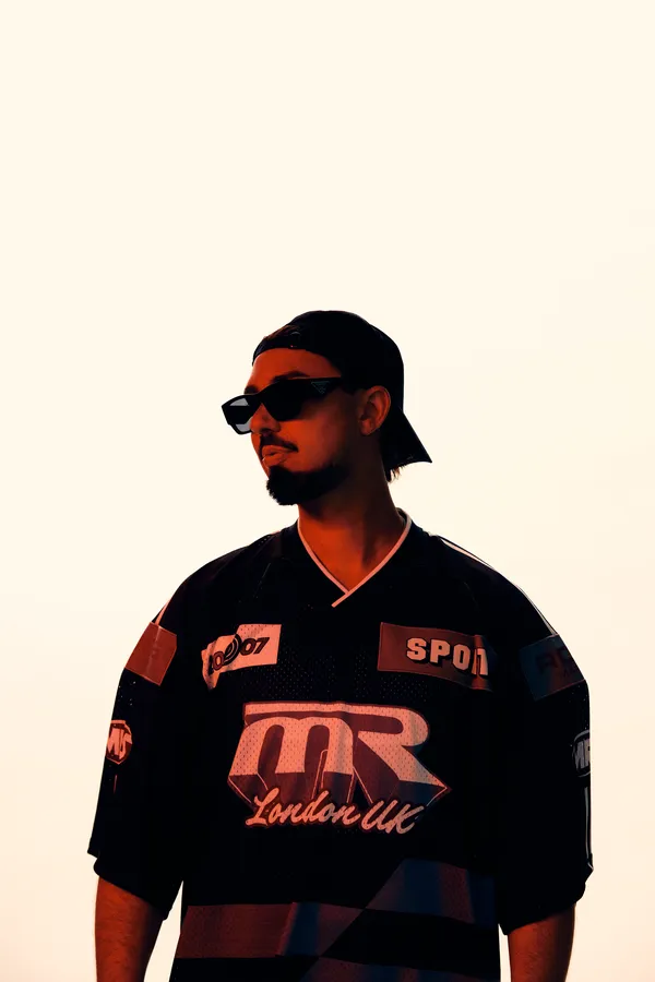 Sonny Fodera in sunglasses and a black jersey, lit by low sun